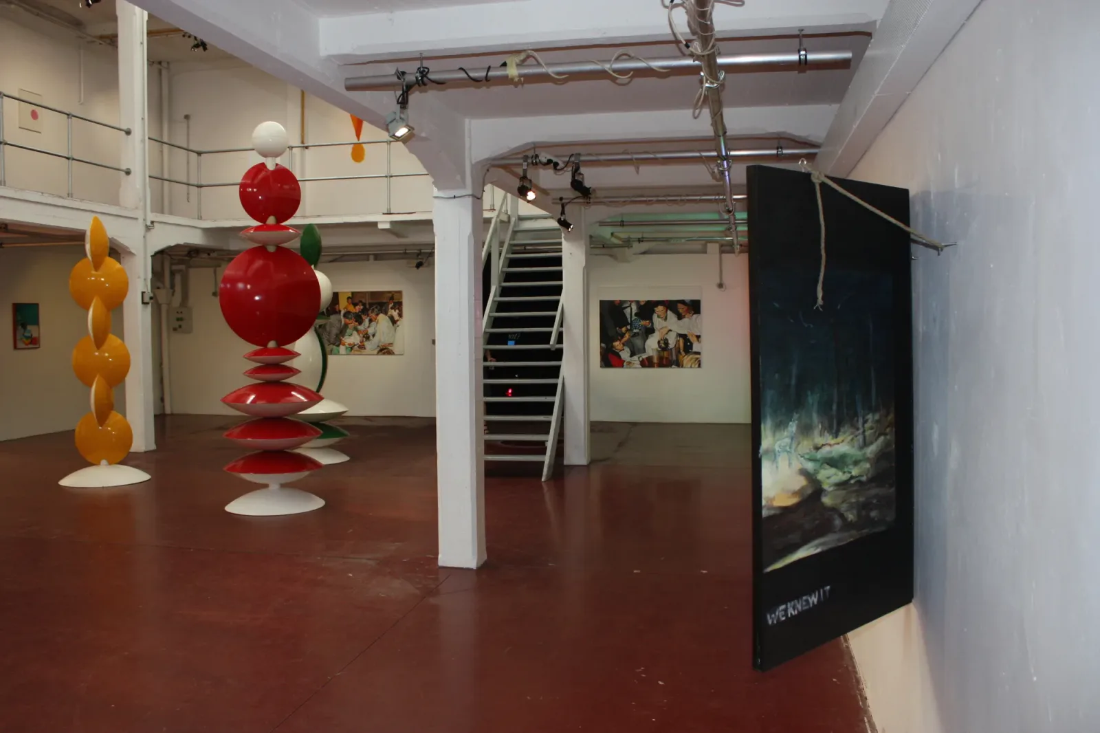 Brussels 8, 2018, vue d'exposition, La montagne, Bruxelles d'Aurian Guerard des Lauriers. La galerie, avec des sculptures en disques empilés et la peinture de forêt à droite.